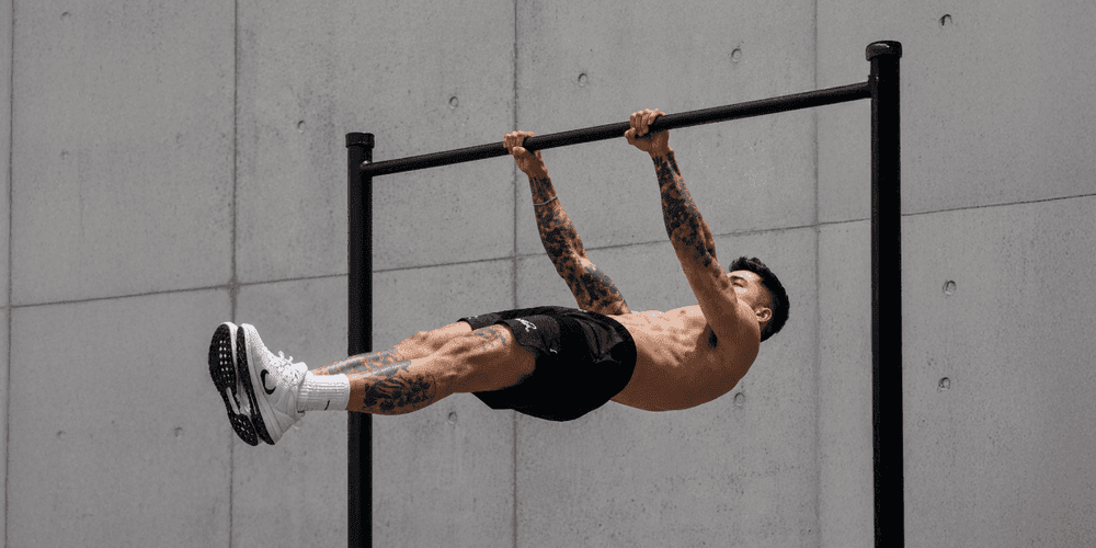 Athlete demonstrating an advanced calisthenics bodyweight exercise on a pull-up bar