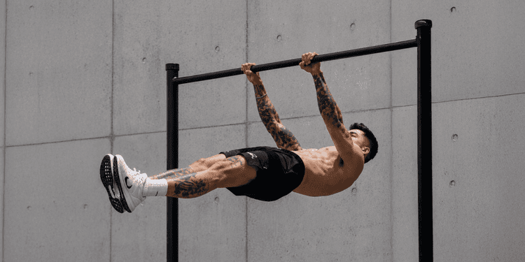 Athlete demonstrating an advanced calisthenics bodyweight exercise on a pull-up bar