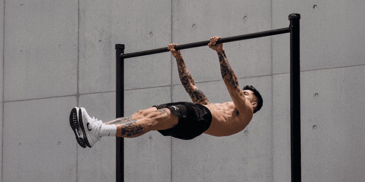 Athlete demonstrating an advanced calisthenics bodyweight exercise on a pull-up bar