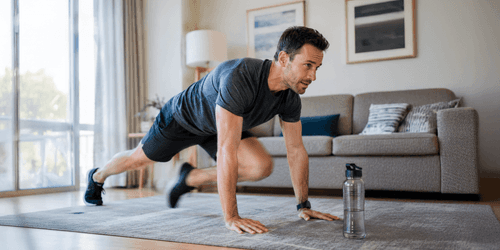 An adult performing mountain climbers in a high plank position, one knee driven toward the chest